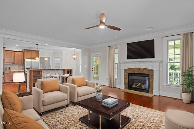 3005 Canopy Woods Dr, Apex, NC 27539 - living area featuring wood finished floors, ceiling fan, a fireplace, crown molding, and recessed lighting