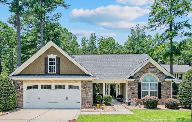 72 Orchard Falls Dr, Spring Lake, NC 28390 - view of front of property featuring driveway, stone siding, an attached garage, and roof with shingles