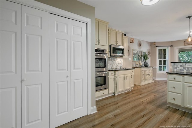 72 Orchard Falls Dr, Spring Lake, NC 28390 - kitchen featuring stainless steel appliances, dark countertops, tasteful backsplash, and light wood-type flooring