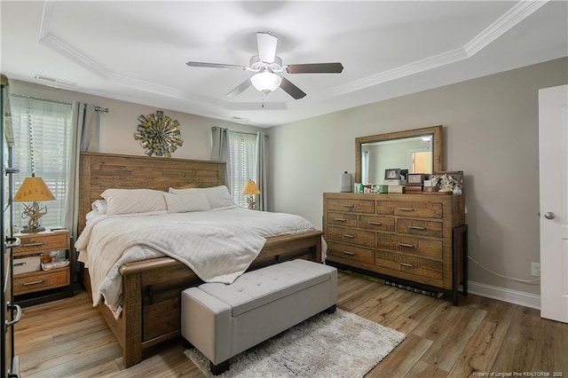 72 Orchard Falls Dr, Spring Lake, NC 28390 - bedroom featuring a tray ceiling, multiple windows, light wood-style floors, ornamental molding, and a ceiling fan