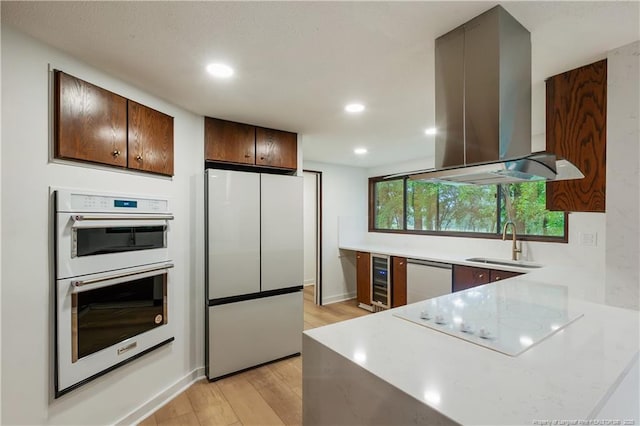 916 Rays Bridge Rd, Whispering Pines, NC 28327 - kitchen featuring white appliances, island range hood, light wood-style floors, light countertops, and recessed lighting
