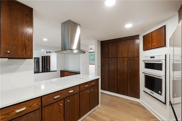 916 Rays Bridge Rd, Whispering Pines, NC 28327 - kitchen with white appliances, light wood-style flooring, island range hood, light countertops, and recessed lighting