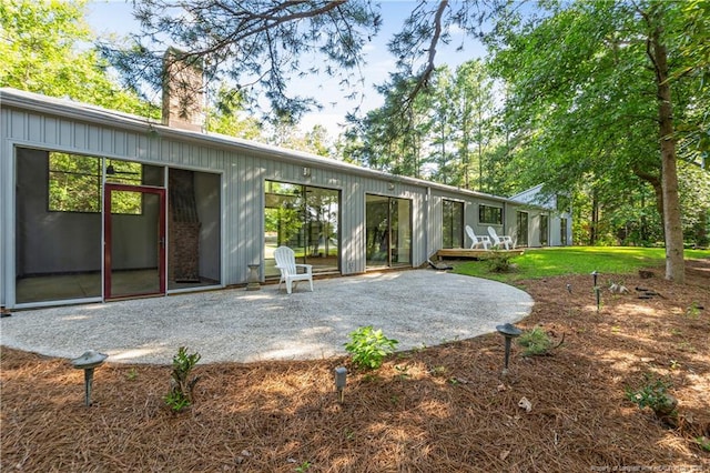 916 Rays Bridge Rd, Whispering Pines, NC 28327 - rear view of house with a patio area, a chimney, and board and batten siding