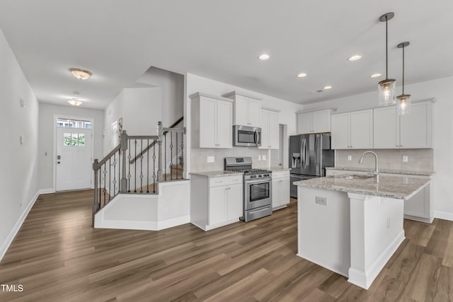 1126 Apogee Dr, Durham, NC 27713 - kitchen featuring stainless steel appliances, decorative backsplash, dark wood-style flooring, white cabinets, and hanging light fixtures