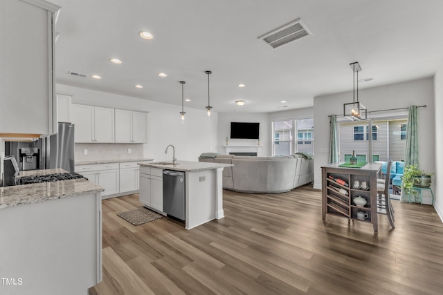1126 Apogee Dr, Durham, NC 27713 - kitchen with appliances with stainless steel finishes, recessed lighting, open floor plan, light wood finished floors, and white cabinets