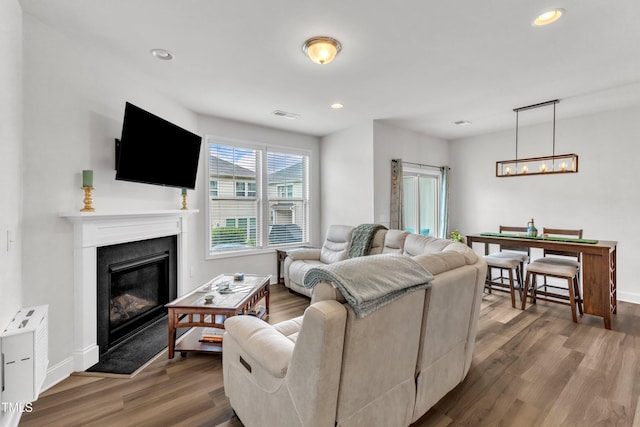 1126 Apogee Dr, Durham, NC 27713 - living area featuring dark wood finished floors, a fireplace with flush hearth, recessed lighting, and a chandelier