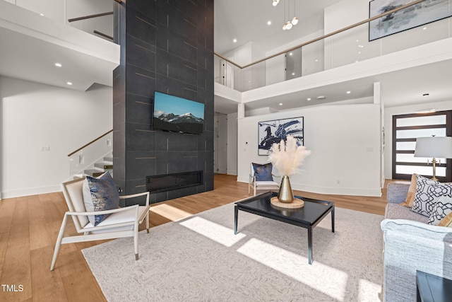1616 Hunting Ridge Rd, Raleigh, NC 27615 - living room with a towering ceiling, stairway, wood finished floors, recessed lighting, and a large fireplace