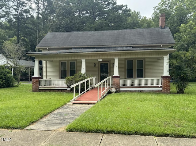 220 E Branch St, Spring Hope, NC 27882 - view of front facade with a porch, a chimney, a front yard, and roof with shingles