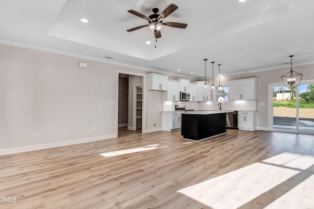 134 Cherrybirch Ln, Zebulon, NC 27597 - kitchen featuring appliances with stainless steel finishes, a raised ceiling, a center island, open floor plan, and ceiling fan