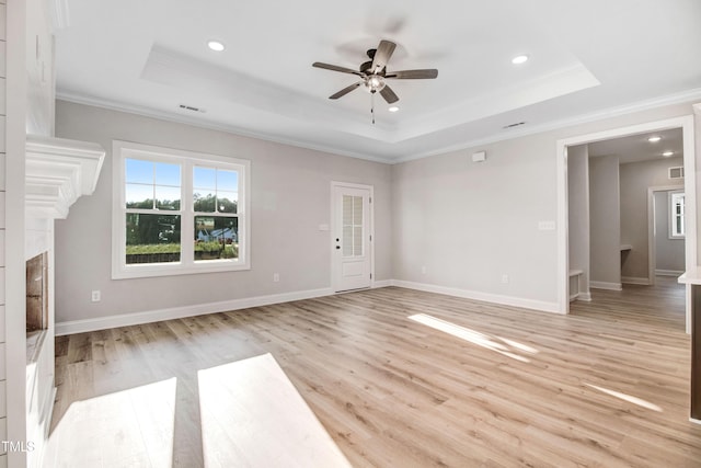 134 Cherrybirch Ln, Zebulon, NC 27597 - unfurnished living room featuring a raised ceiling, ornamental molding, a ceiling fan, light wood-style flooring, and recessed lighting