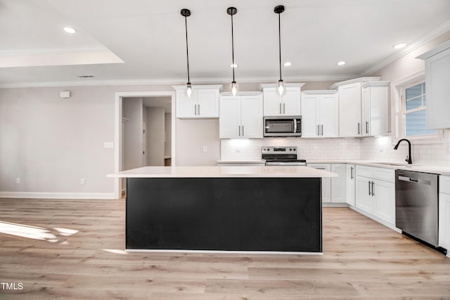 134 Cherrybirch Ln, Zebulon, NC 27597 - kitchen with stainless steel appliances, a center island, decorative backsplash, ornamental molding, and light wood-style flooring
