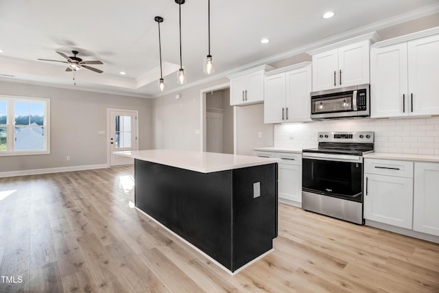 134 Cherrybirch Ln, Zebulon, NC 27597 - kitchen featuring appliances with stainless steel finishes, crown molding, a kitchen island, light wood-type flooring, and decorative backsplash