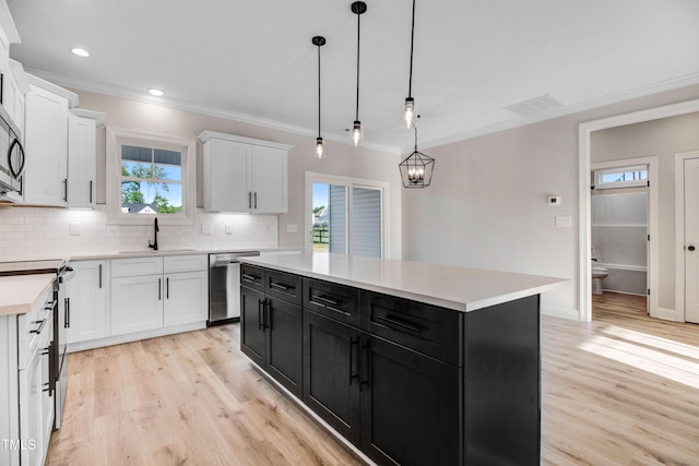 134 Cherrybirch Ln, Zebulon, NC 27597 - kitchen featuring stainless steel appliances, dark cabinetry, light wood finished floors, white cabinetry, and ornamental molding