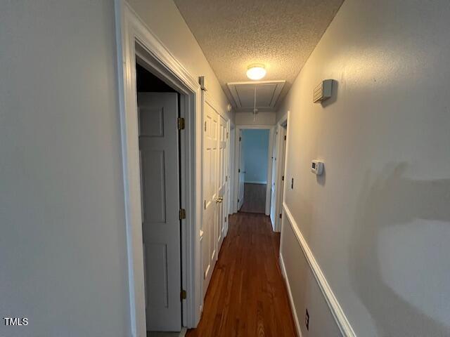 2856 Nutbush Rd, Henderson, NC 27537 - hall featuring attic access, a textured ceiling, and dark wood finished floors