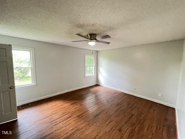 2856 Nutbush Rd, Henderson, NC 27537 - empty room with dark wood-style flooring, ceiling fan, and a textured ceiling