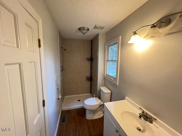 2856 Nutbush Rd, Henderson, NC 27537 - bathroom with wood finished floors, a shower stall, vanity, and a textured ceiling