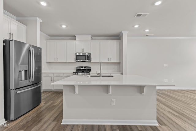 5721 Woodlawn Dr, Durham, NC 27703 - kitchen with stainless steel appliances, crown molding, white cabinetry, light countertops, and wood finished floors