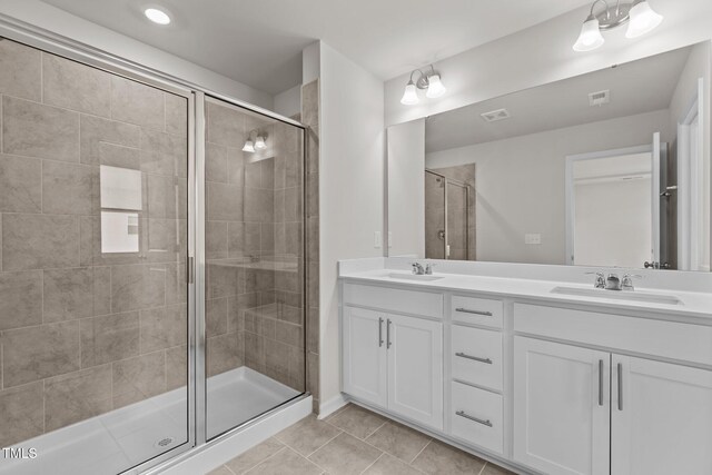 5721 Woodlawn Dr, Durham, NC 27703 - bathroom featuring double vanity, tile patterned floors, and a stall shower