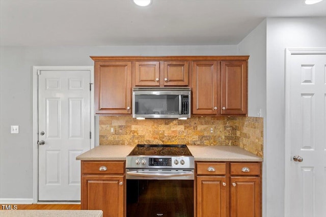 20 Allyson Ct, Youngsville, NC 27596 - kitchen featuring stainless steel appliances, light countertops, and brown cabinetry