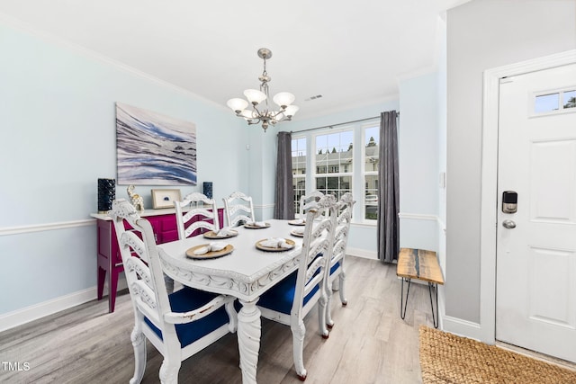 7645 Winners Edge St, Raleigh, NC 27617 - dining area with a chandelier, light wood-style floors, and ornamental molding