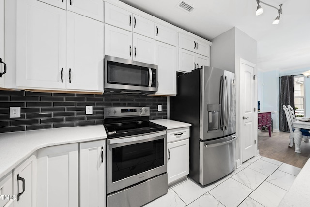 7645 Winners Edge St, Raleigh, NC 27617 - kitchen featuring stainless steel appliances, light countertops, and white cabinetry