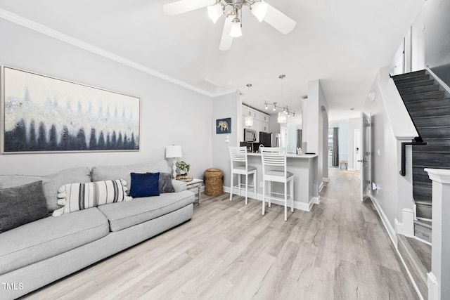 7645 Winners Edge St, Raleigh, NC 27617 - living room with ceiling fan, light wood-style floors, stairs, rail lighting, and ornamental molding