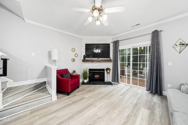 7645 Winners Edge St, Raleigh, NC 27617 - living room featuring wood finished floors, crown molding, a brick fireplace, a ceiling fan, and stairway