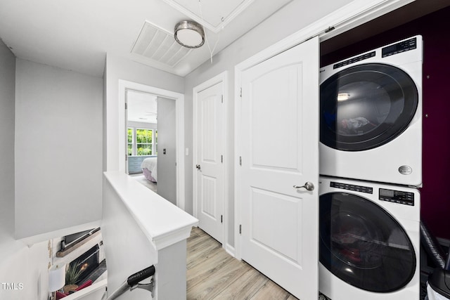 7645 Winners Edge St, Raleigh, NC 27617 - laundry area featuring stacked washer and clothes dryer, attic access, and light wood finished floors