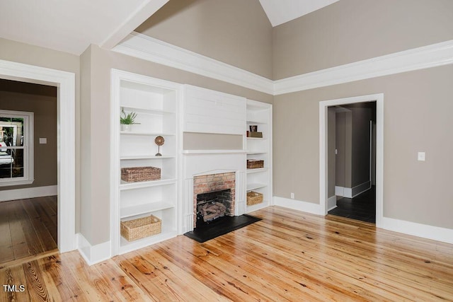 103 N Mckay Ave, Dunn, NC 28334 - unfurnished living room with light wood-style floors, built in features, a fireplace, and high vaulted ceiling