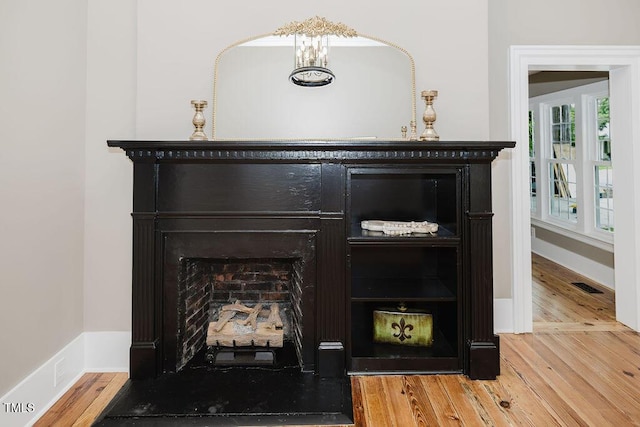 103 N Mckay Ave, Dunn, NC 28334 - detailed view of wood finished floors, a fireplace, and a chandelier