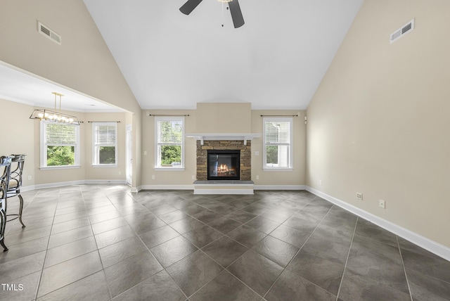 347 Country Mill Way, Fuquay Varina, NC 27526 - unfurnished living room featuring a ceiling fan, a stone fireplace, a chandelier, dark tile patterned floors, and high vaulted ceiling