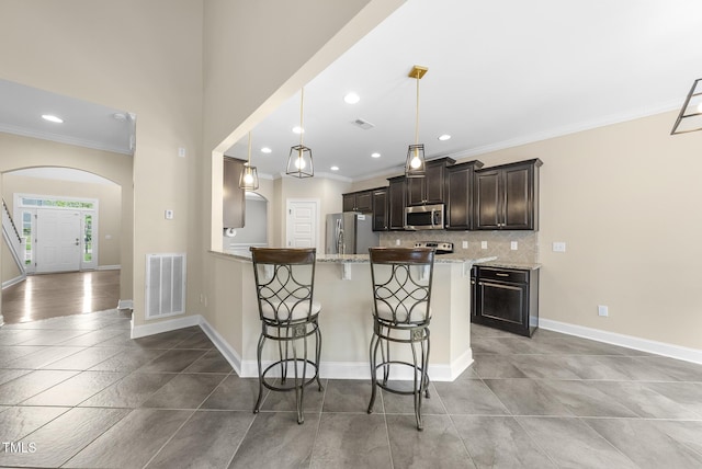 347 Country Mill Way, Fuquay Varina, NC 27526 - kitchen featuring appliances with stainless steel finishes, a breakfast bar, ornamental molding, recessed lighting, and tasteful backsplash