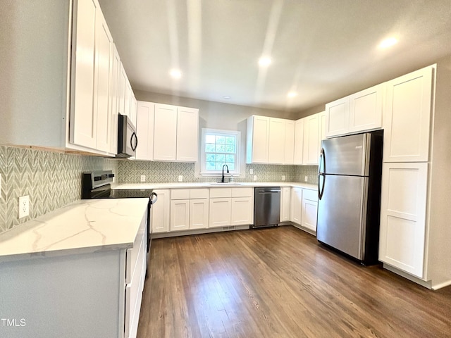 6 First St, Franklinton, NC 27525 - kitchen featuring appliances with stainless steel finishes, light stone countertops, dark wood-style flooring, backsplash, and white cabinets