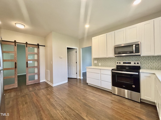 6 First St, Franklinton, NC 27525 - kitchen featuring stainless steel appliances, tasteful backsplash, white cabinets, light countertops, and a barn door