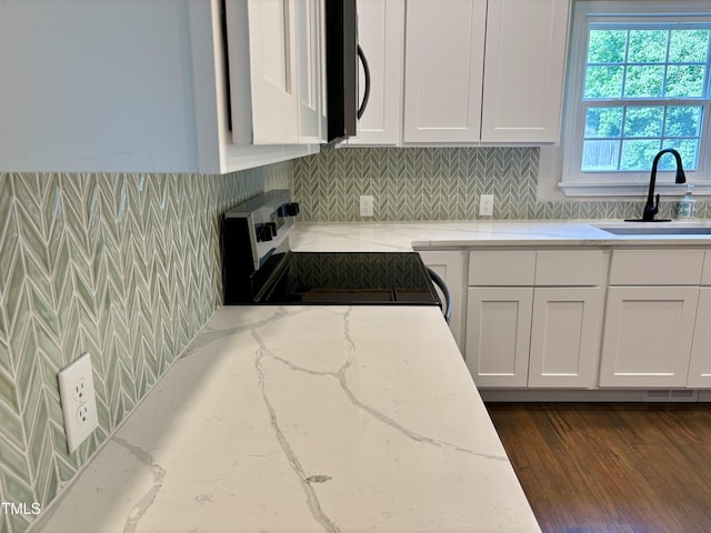 6 First St, Franklinton, NC 27525 - kitchen featuring white electric range, white cabinets, stainless steel microwave, and decorative backsplash