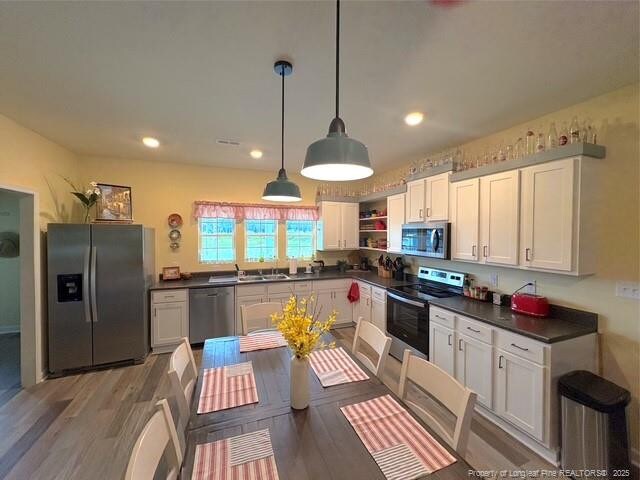 893 Blanchard Rd, Saint Pauls, NC 28384 - kitchen featuring appliances with stainless steel finishes, dark countertops, open shelves, white cabinetry, and light wood-type flooring