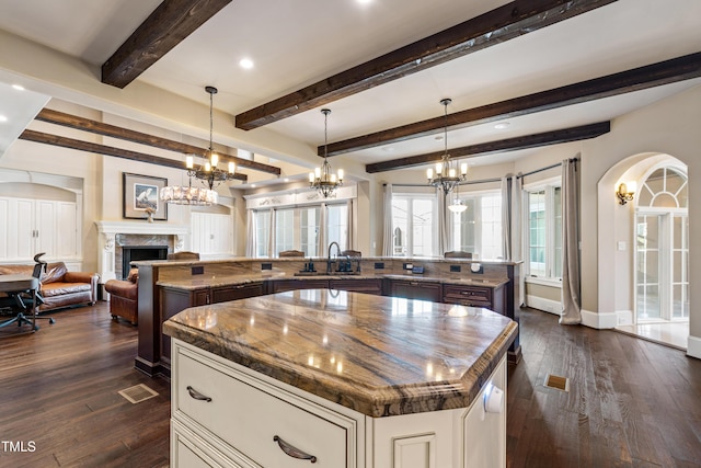19 San Rimini Way, Durham, NC 27707 - kitchen featuring a large island with sink, a high end fireplace, a chandelier, open floor plan, and dark wood finished floors