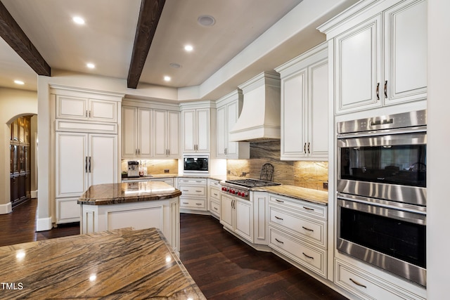 19 San Rimini Way, Durham, NC 27707 - kitchen featuring built in appliances, arched walkways, beam ceiling, dark wood-type flooring, and tasteful backsplash