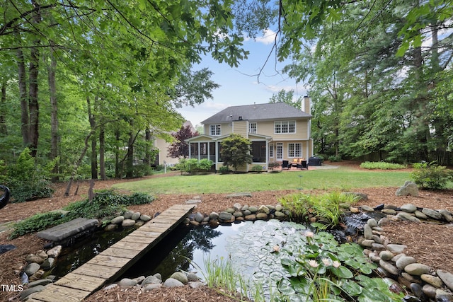 107 Ackworth Ct, Cary, NC 27519 - back of house featuring a chimney, a sunroom, a lawn, and a small pond
