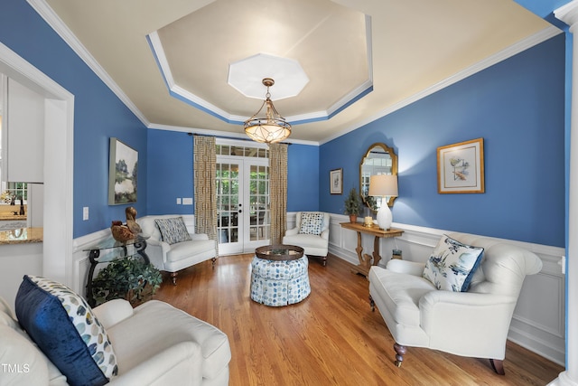 107 Ackworth Ct, Cary, NC 27519 - living room featuring a tray ceiling, french doors, wainscoting, wood finished floors, and ornamental molding