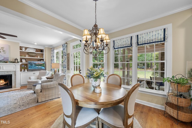 107 Ackworth Ct, Cary, NC 27519 - dining space with crown molding, a chandelier, light wood-style flooring, a fireplace, and ceiling fan
