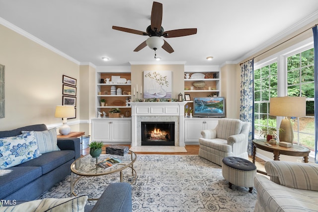 107 Ackworth Ct, Cary, NC 27519 - living area with crown molding, built in features, a ceiling fan, a fireplace with flush hearth, and wood finished floors