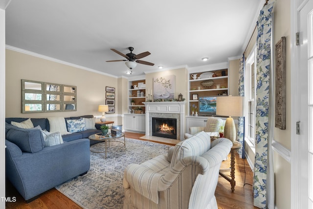 107 Ackworth Ct, Cary, NC 27519 - living room with a fireplace with flush hearth, wood finished floors, ceiling fan, ornamental molding, and built in shelves