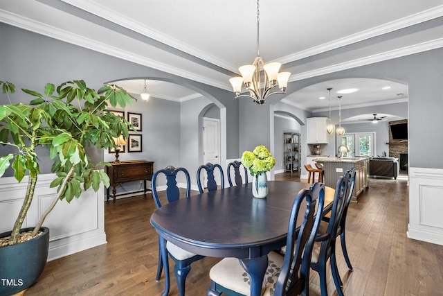 124 Moss Creek Pl, Fuquay Varina, NC 27526 - dining space with arched walkways, a chandelier, dark wood-type flooring, and ornamental molding