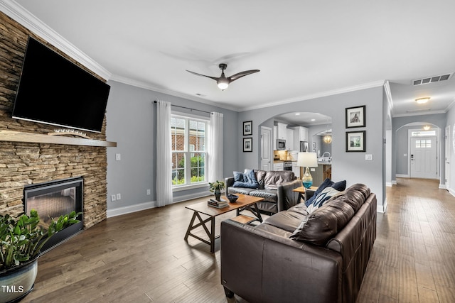 124 Moss Creek Pl, Fuquay Varina, NC 27526 - living area with arched walkways, a ceiling fan, ornamental molding, hardwood / wood-style floors, and a stone fireplace