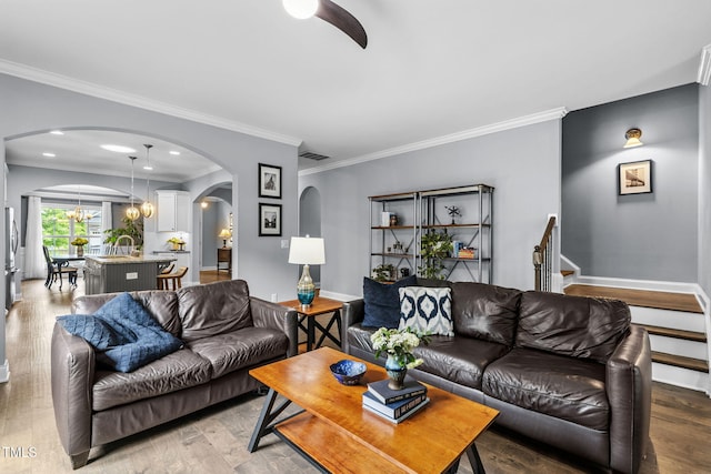 124 Moss Creek Pl, Fuquay Varina, NC 27526 - living room with arched walkways, light wood-style flooring, crown molding, and a chandelier