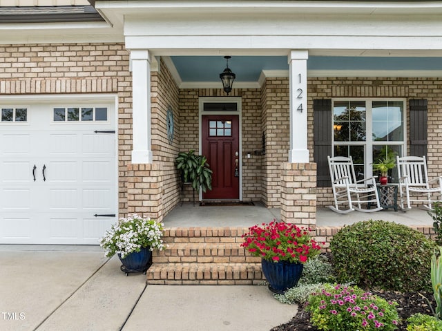124 Moss Creek Pl, Fuquay Varina, NC 27526 - doorway to property with covered porch, brick siding, an attached garage, and driveway