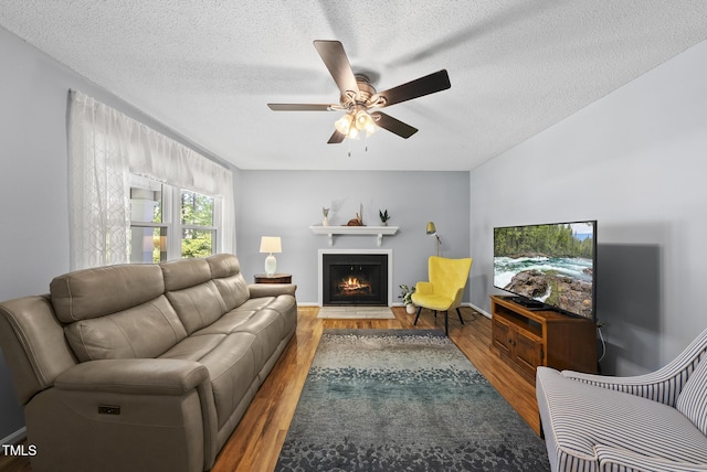 8613 Lobelia St, Raleigh, NC 27603 - living area with ceiling fan, a fireplace with flush hearth, wood finished floors, and a textured ceiling