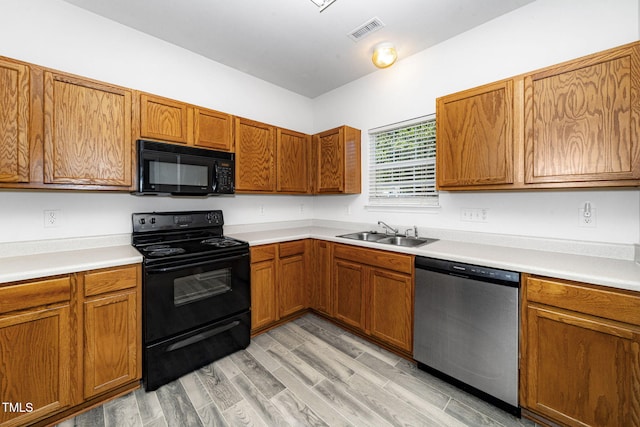 524 Summer Breeze Dr, Durham, NC 27704 - kitchen with black appliances, brown cabinets, light countertops, and light wood-style floors