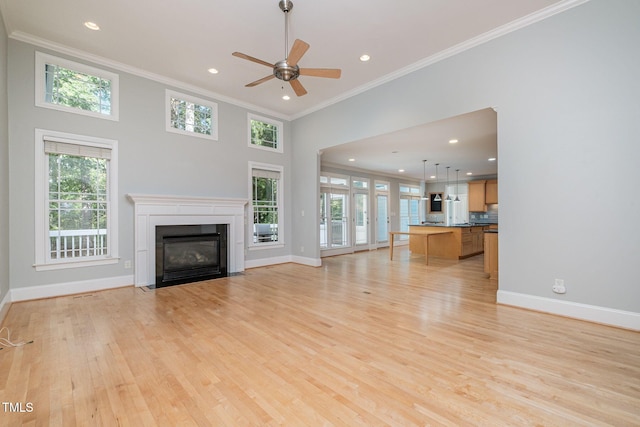 11 Kingswood Ln, Chapel Hill, NC 27517 - unfurnished living room featuring crown molding, plenty of natural light, light wood-type flooring, a fireplace with flush hearth, and a ceiling fan